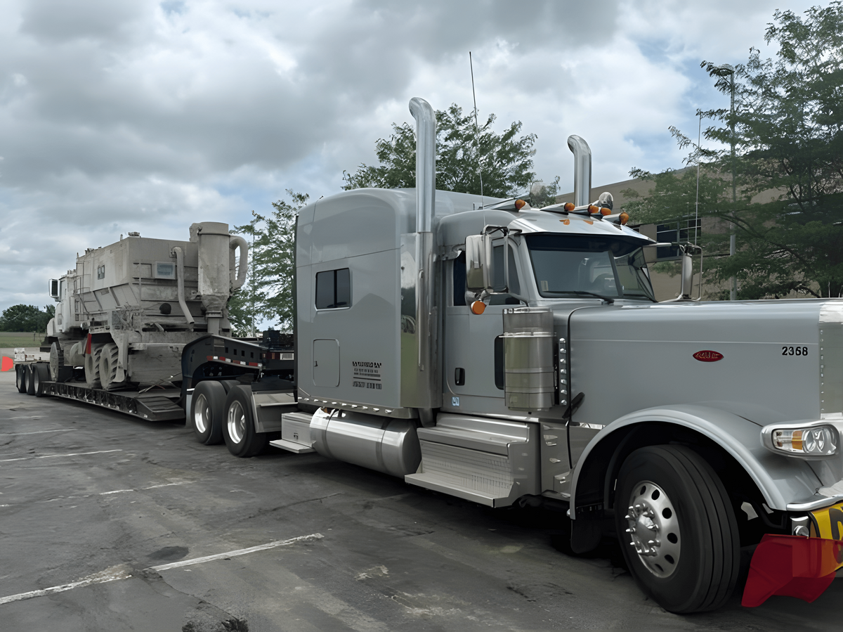 a semi truck with extended cab with a heavy load on a flat-bed trailer parked in a lot